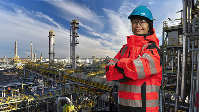 female asian engineer infront of refinery