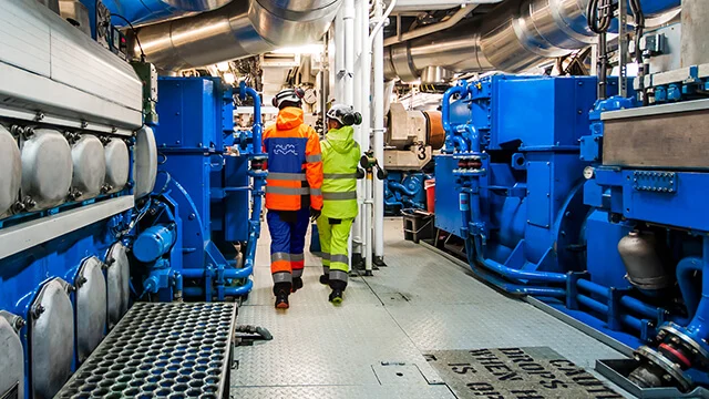 Alfa Laval service engineer touring a ship engine room with customer